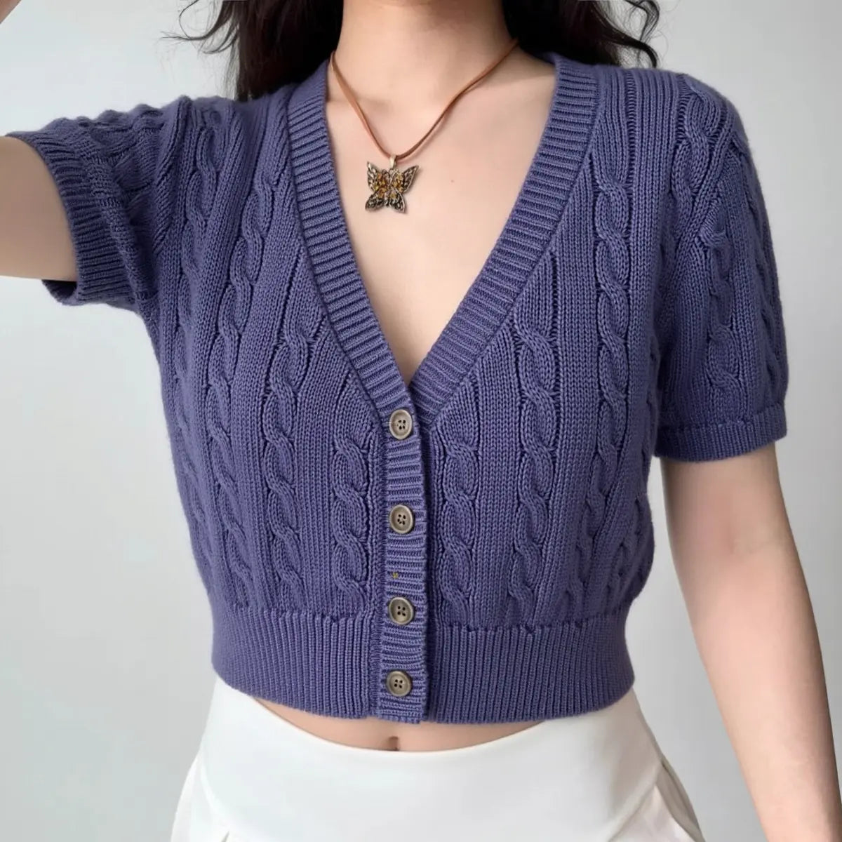 Model wearing purple cable-knit short-sleeve cardigan, cropped button-front sweater