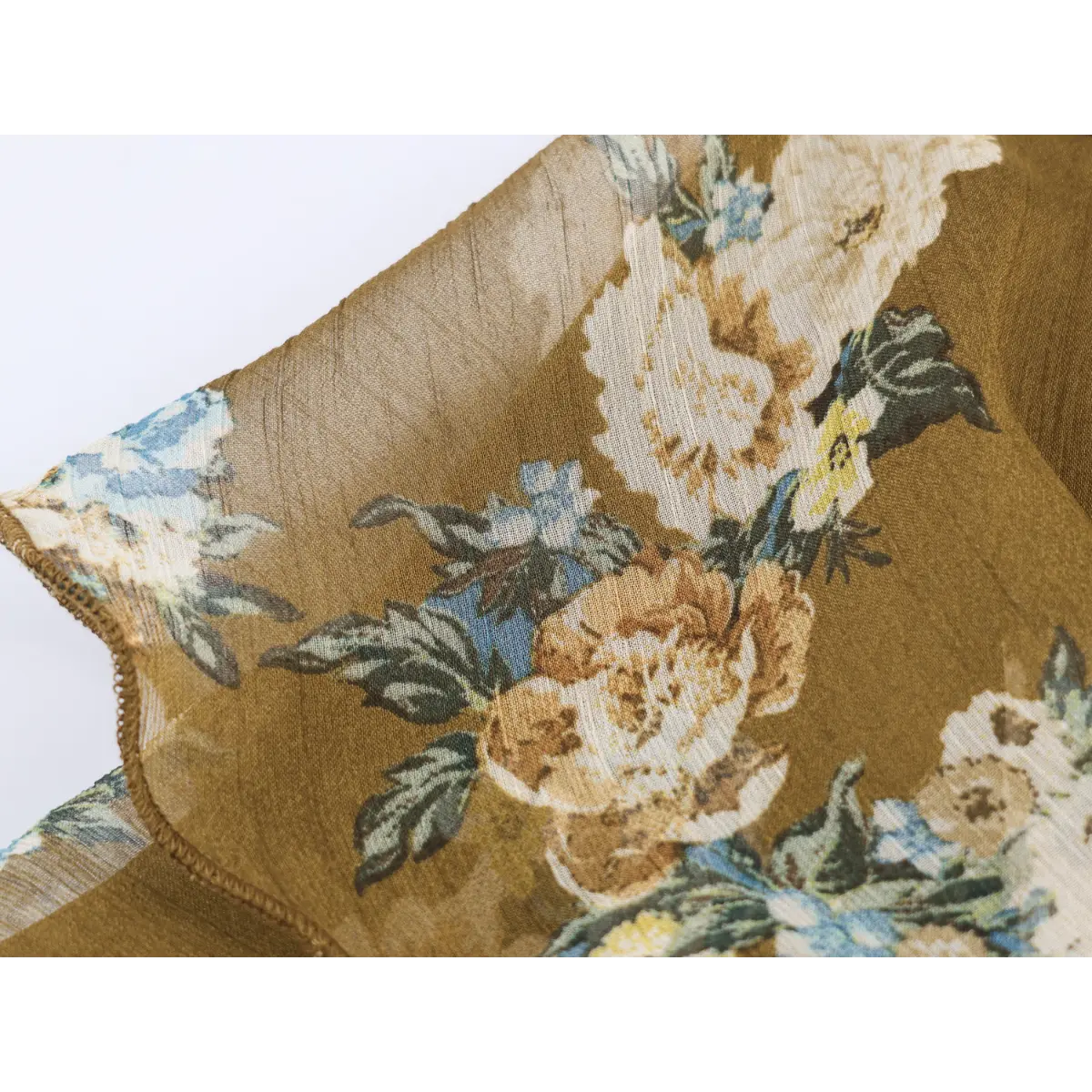 Fabric close-up of vintage peony floral print on crinkled sheer chiffon, warm mustard colorway with blue&cream blooms.