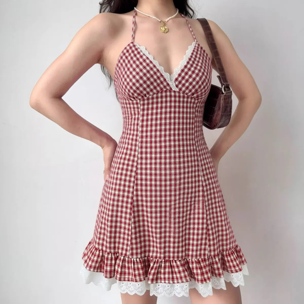 Model wearing red gingham halter mini dress, front view