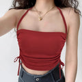 Model wearing red halter-neck cami top with side drawstrings, cropped ruched tank top