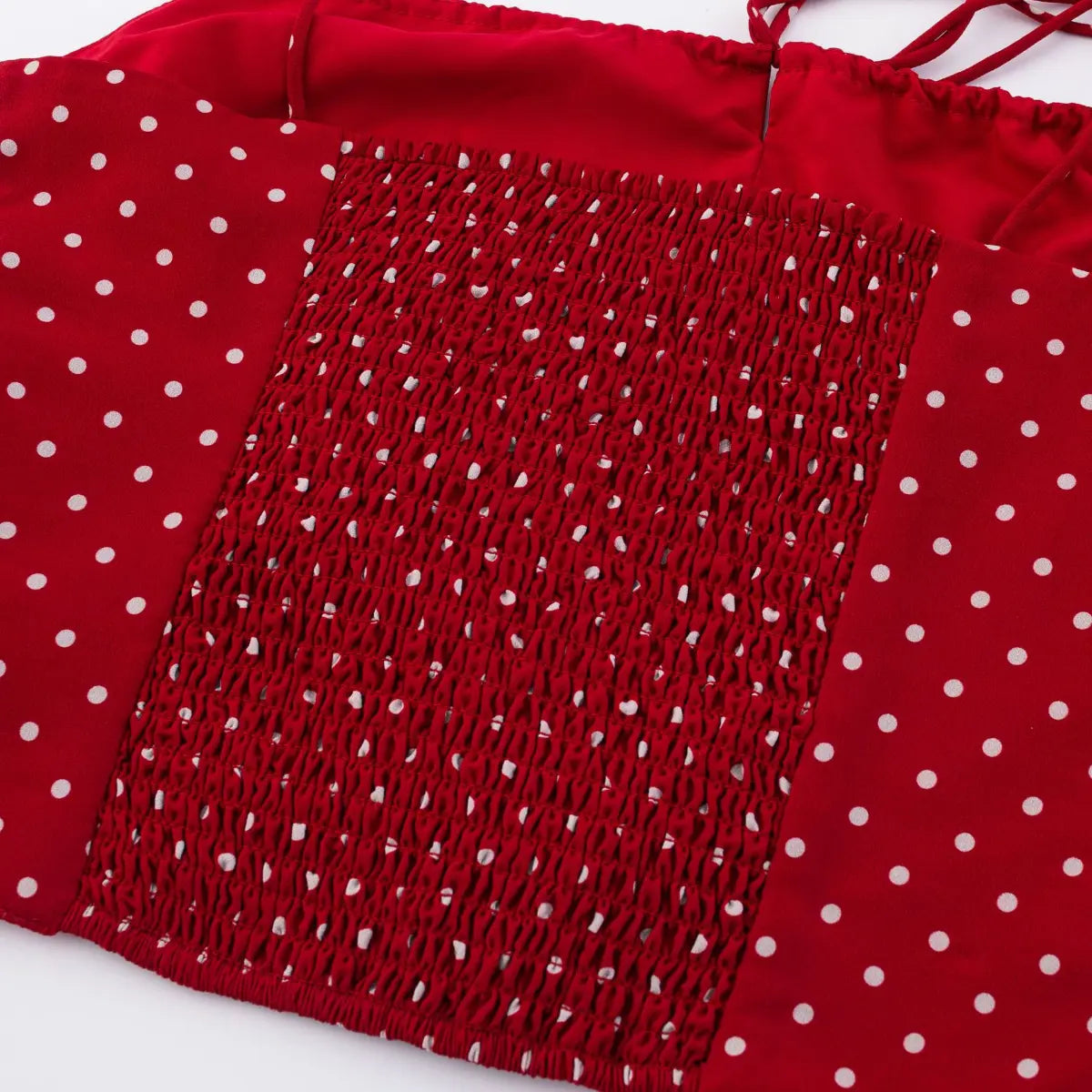 Close-up of smocked back panel on red polka dot cami top