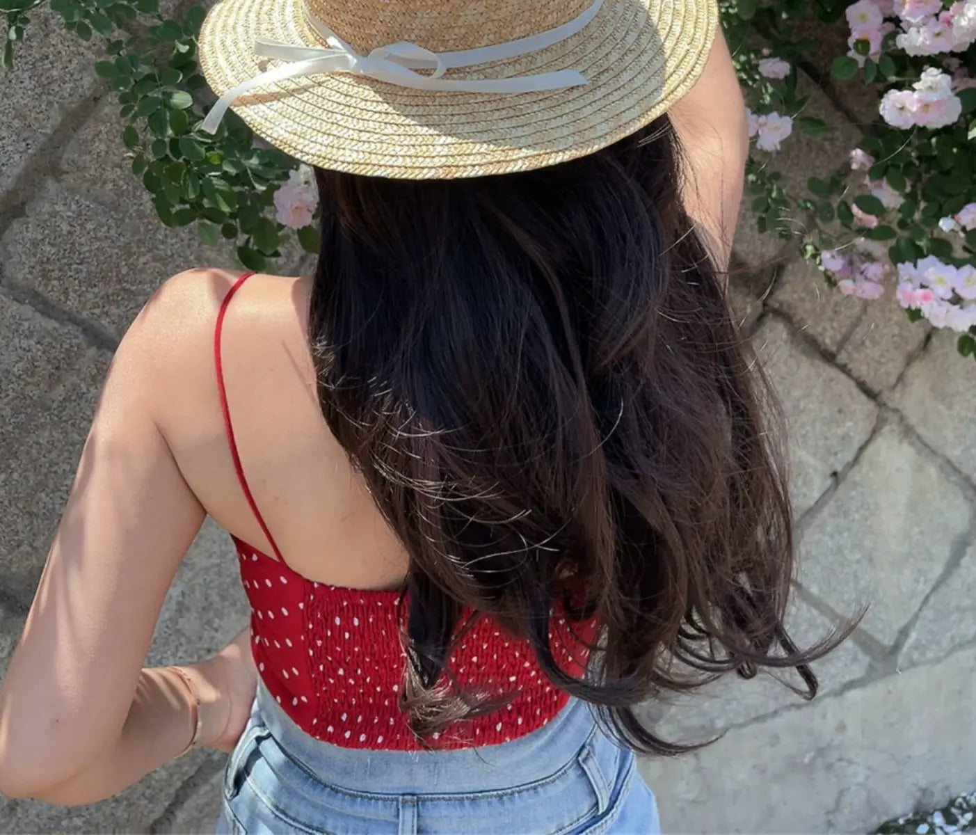 Back view of red polka dot cami top showing the smocked elasticated back panel and thin straps