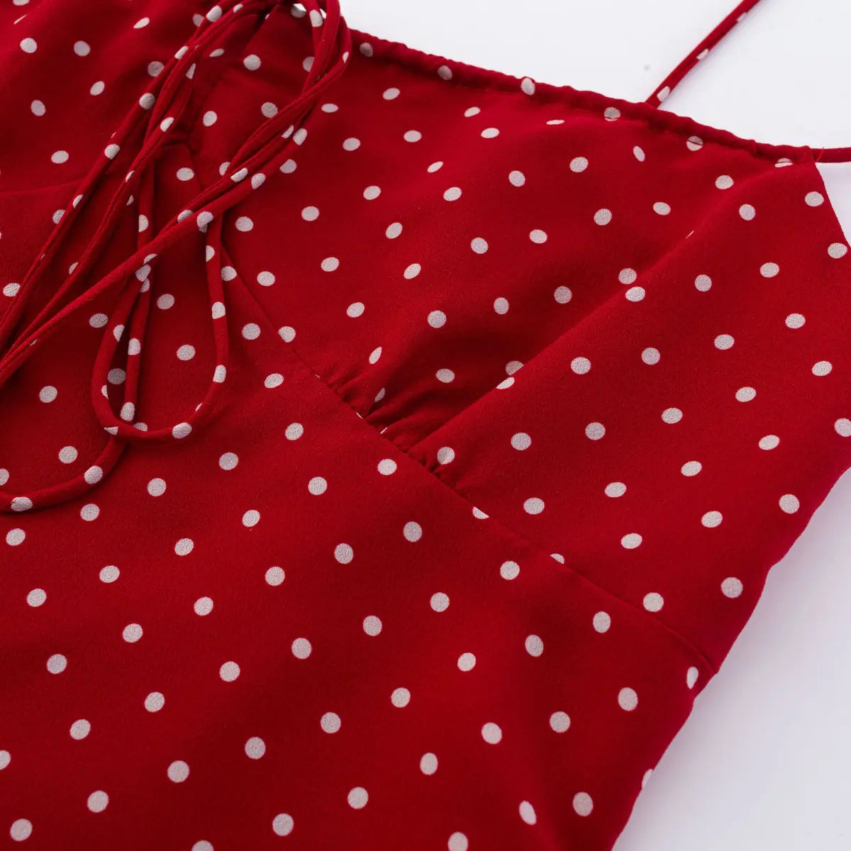 Close-up of fabric texture and lining on red polka dot cami top