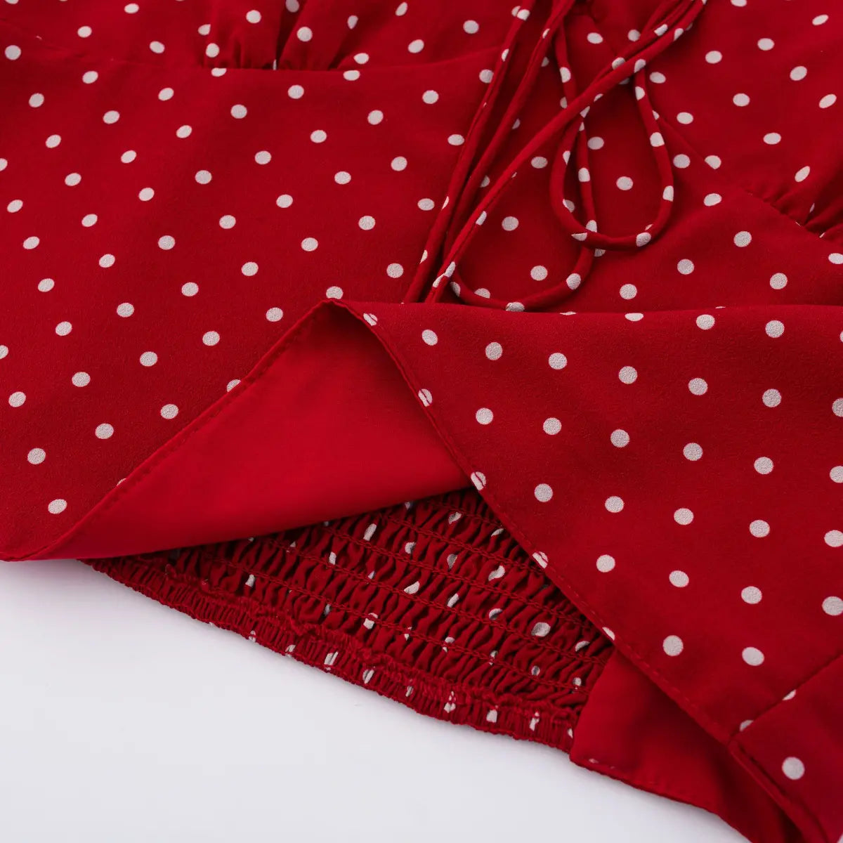Close-up of the inner lining and fabric texture on the red polka dot cami top, showing layered construction