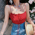 Model wearing red polka dot cami top with front drawstring tie, thin straps, and smocked back