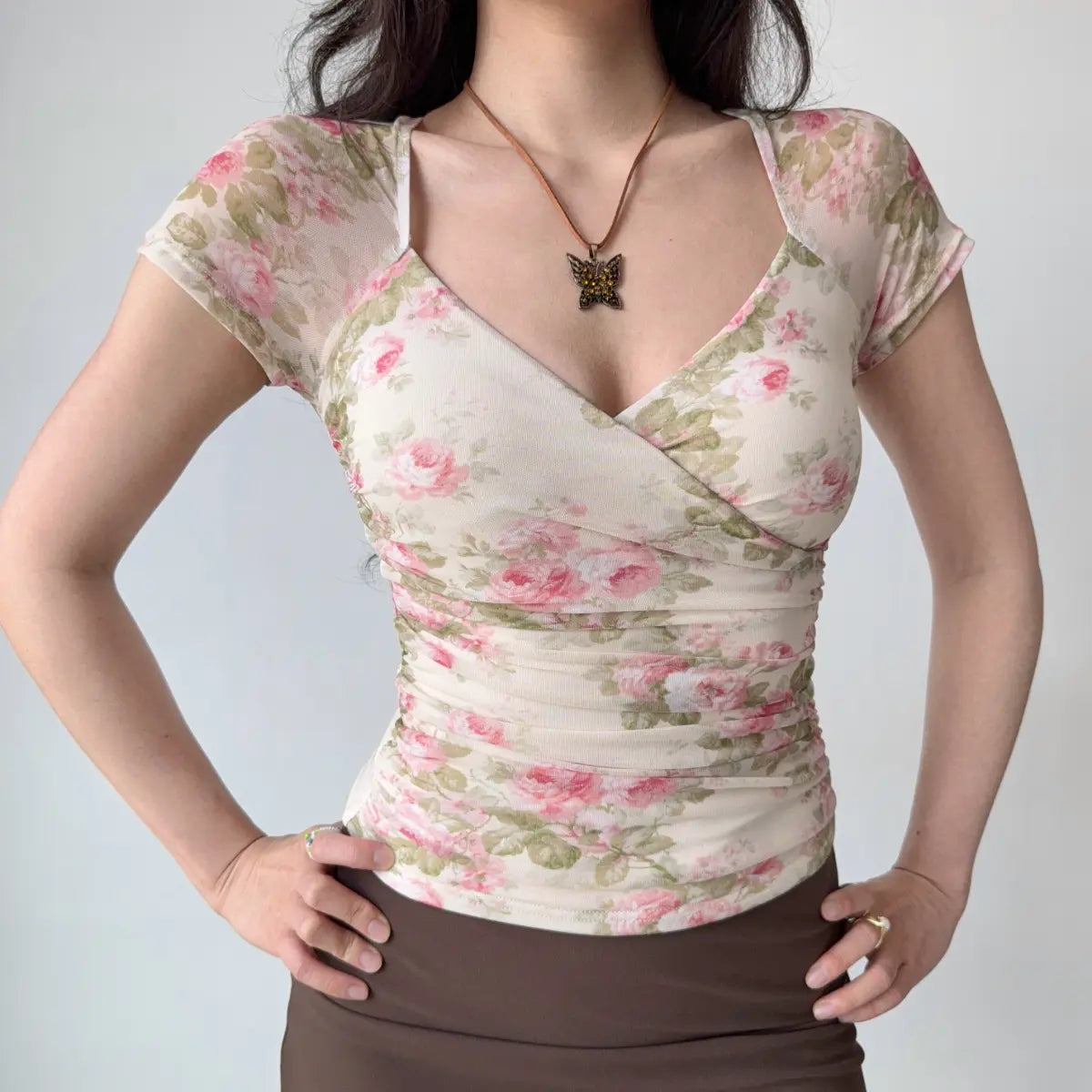 Front view of rose-print sheer mesh top showing the wrap design and floral pattern