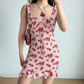 Model wearing pink rose print mini dress with ruffled straps and bodycon fit