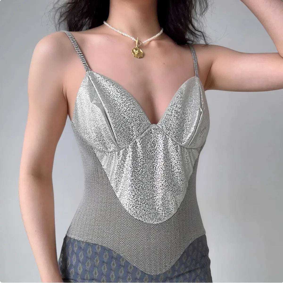 Model wearing silver glitter cami top with herringbone knit panels, fitted bustier-style spaghetti-strap top