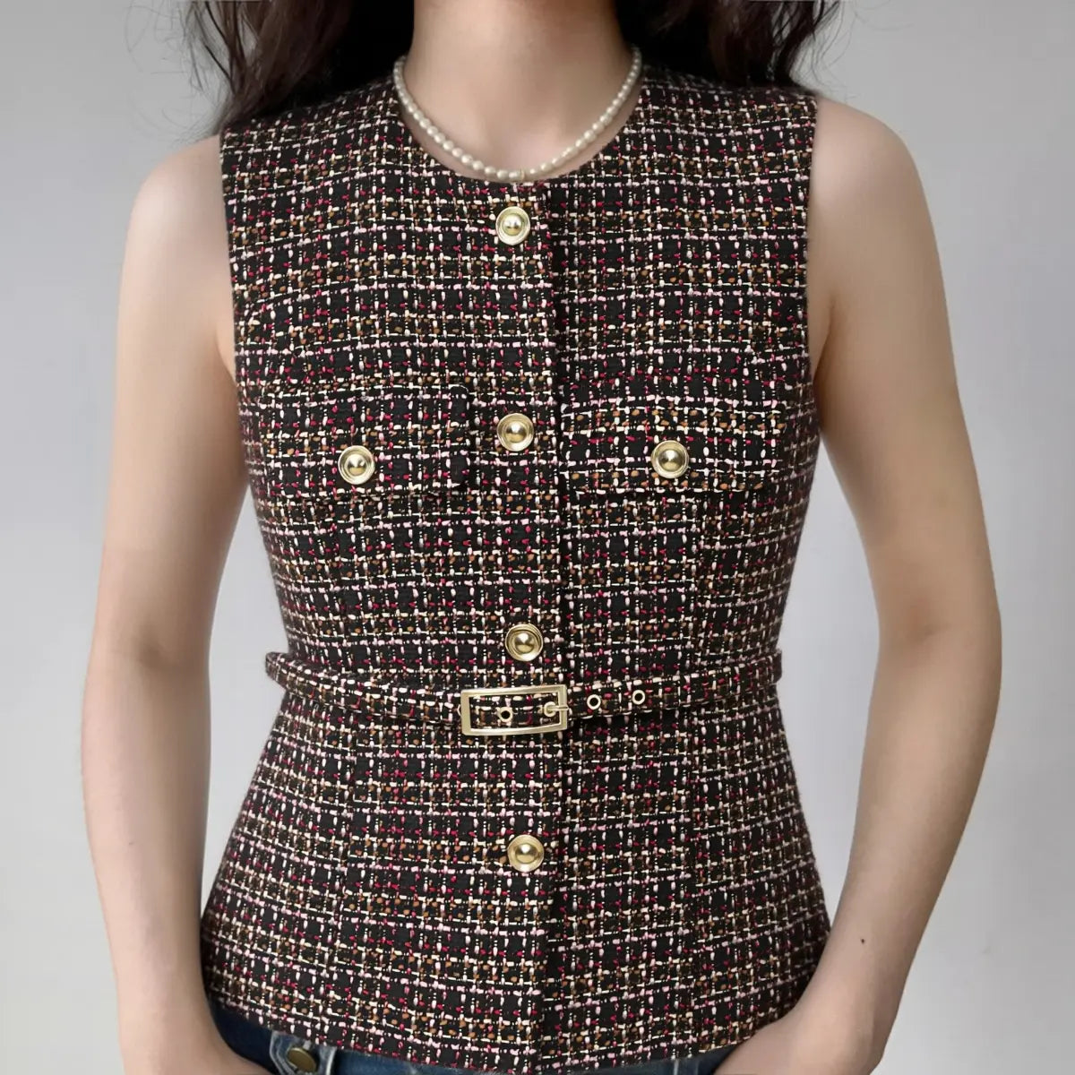 Model wearing tweed sleeveless vest with matching belt and gold buttons, preppy tailored waistcoat