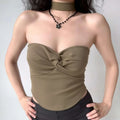 Model wearing twist-front choker-neck strapless tube top with ribbed fabric and curved hem