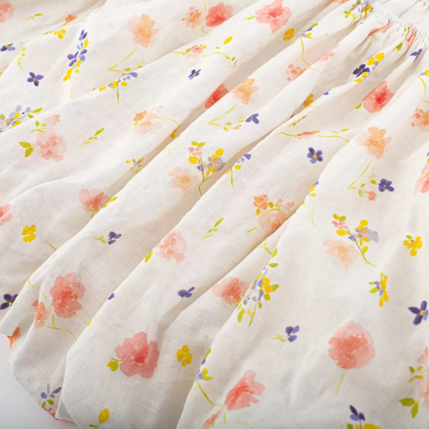 Body fabric texture close-up, watercolor mixed pink yellow purple small flower scattered print, matte textured weave