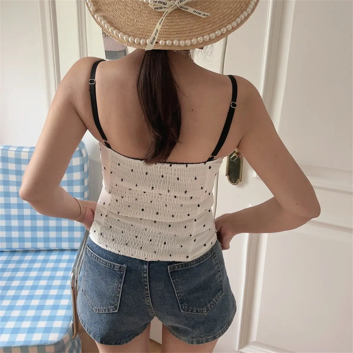 Back view of white polka dot corset cami top with smooth back and wide straps