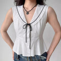 Model wearing white black-trim tie-front peplum vest top, preppy-inspired fitted sleeveless blouse