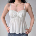 Model wearing white bow-front smocked cami peplum top, feminine flowy summer top