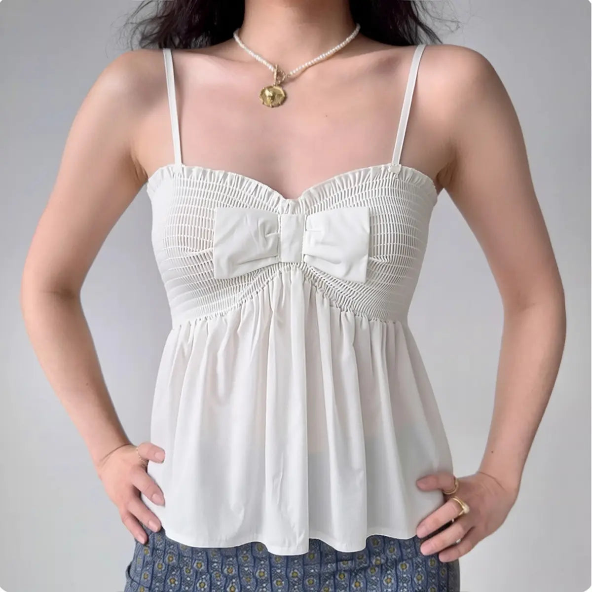 Model wearing white bow-front smocked cami peplum top, feminine flowy summer top