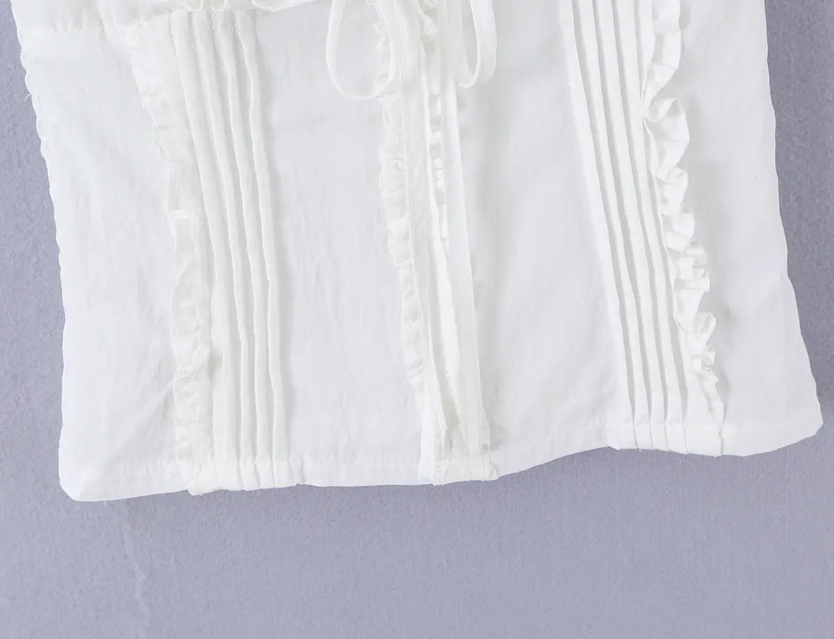 Back view of the white cami top, showing the vertical stitching and smocked panel