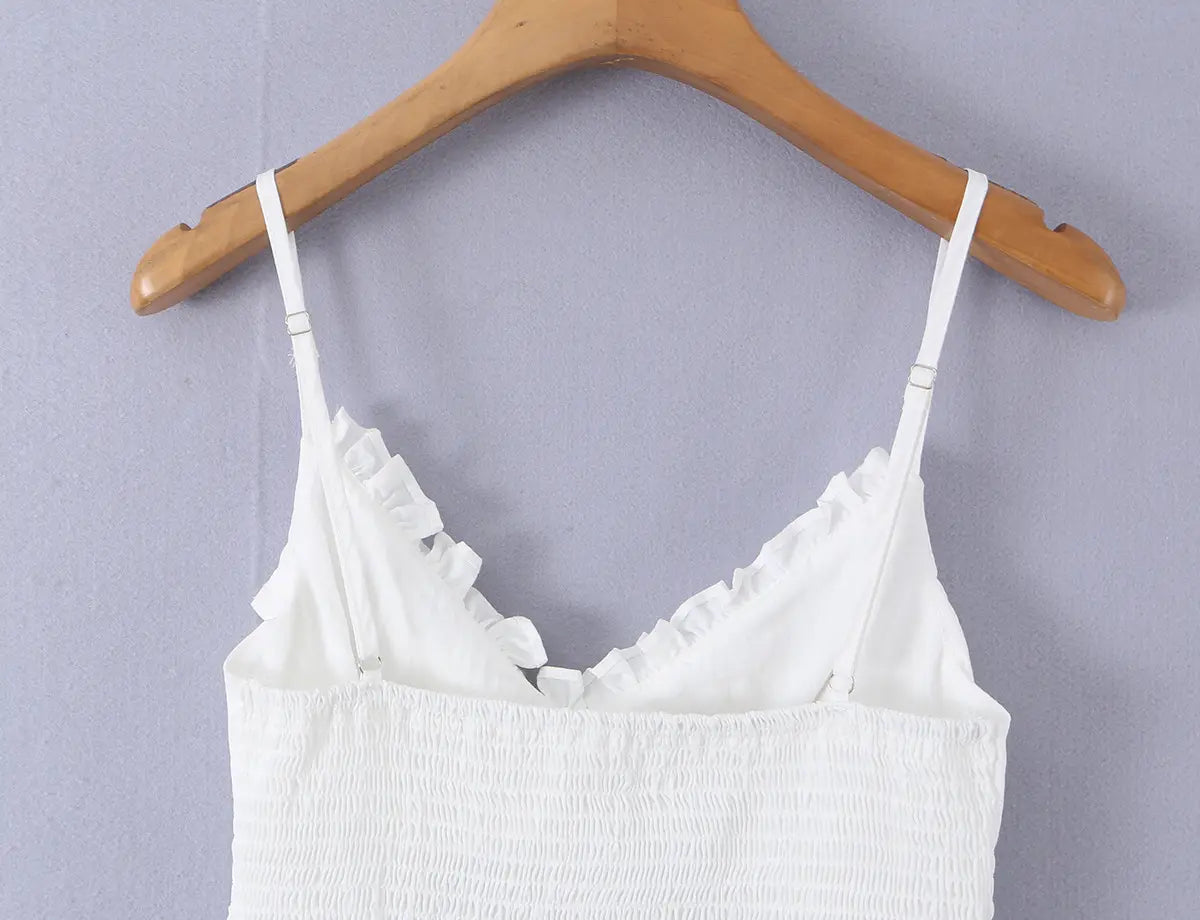 White corset-style cami top hanging on wooden hanger, clean front view