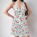 Model wearing white cherry print halter-neck mini dress with lace trim, vintage-inspired summer dress