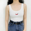 Model wearing white ribbed tank top with red chili pepper embroidery and fitted silhouette