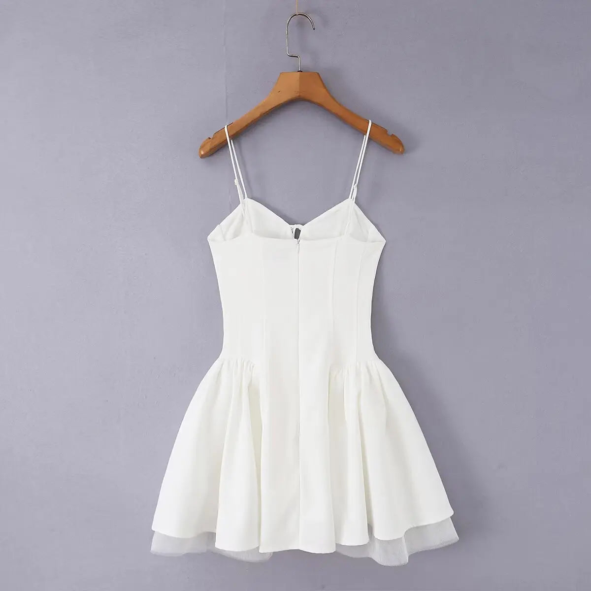 White corset bow mini dress, back view on hanger, grey background