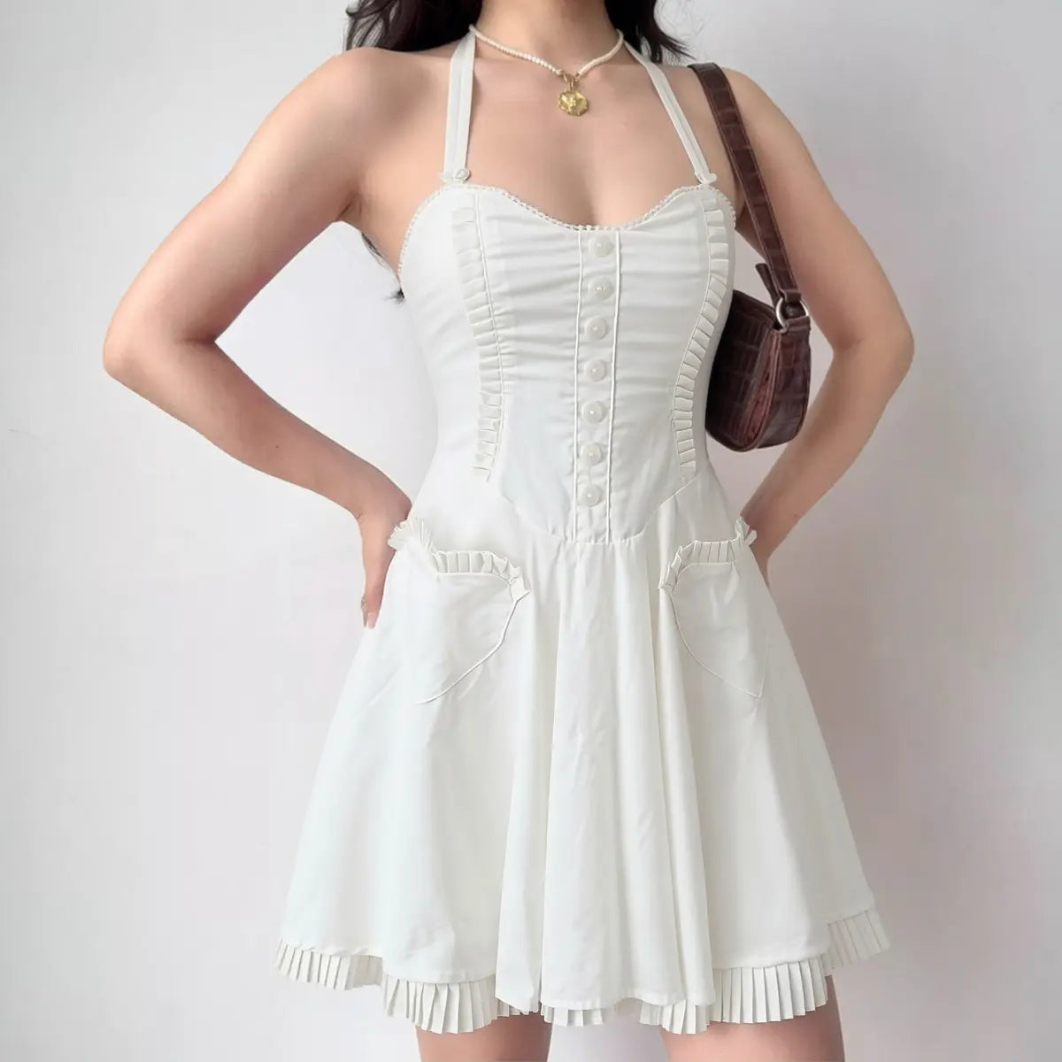 Woman wearing white corset-style halter mini dress with ruffled hem, full front view