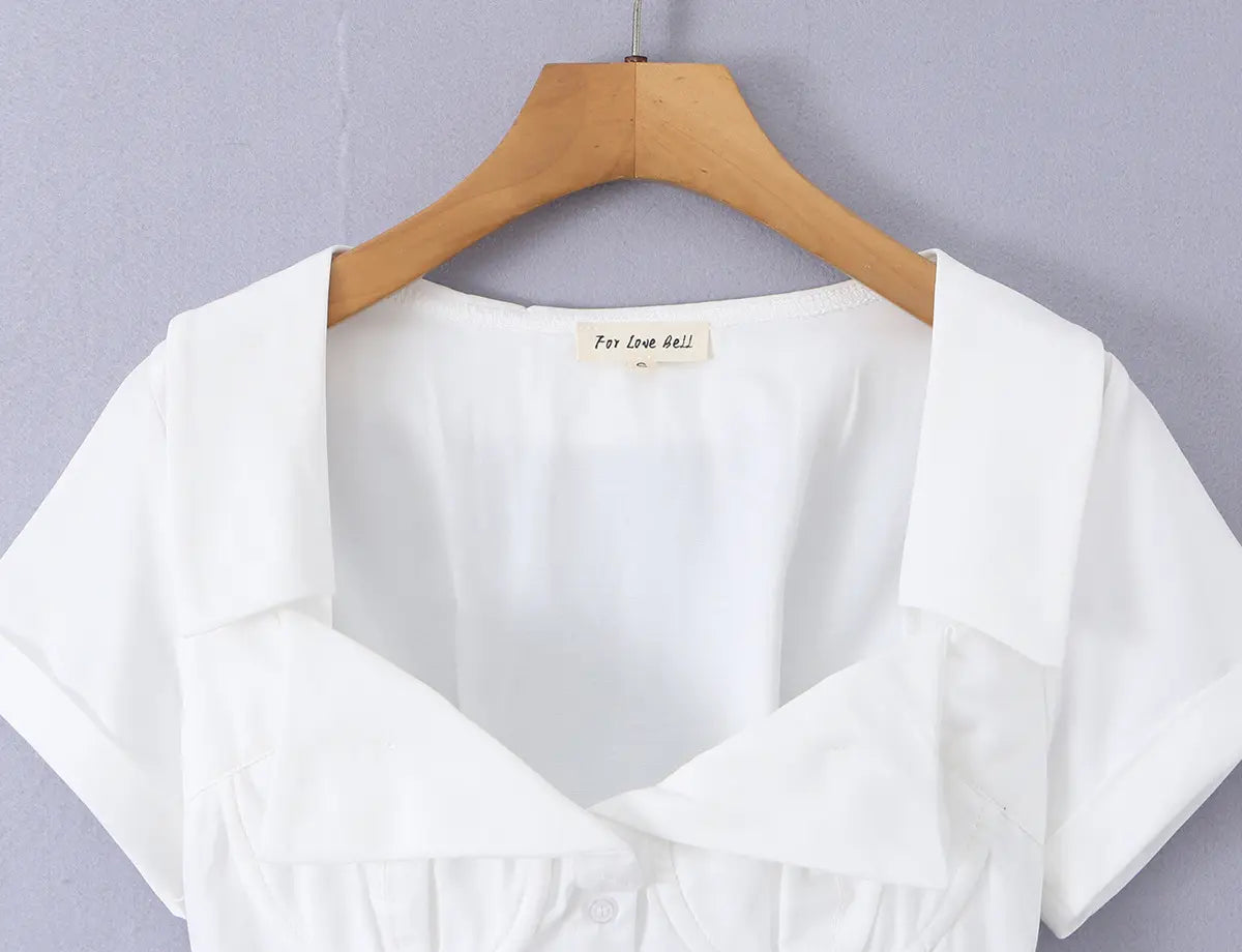White corset-style short-sleeve shirt hanging on wooden hanger, full front view