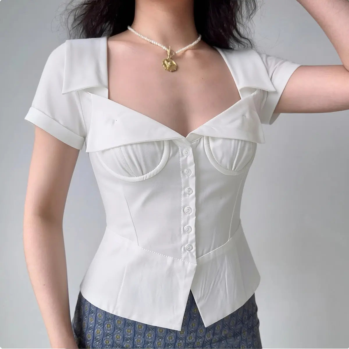 Model in white corset-style short-sleeve top, front view