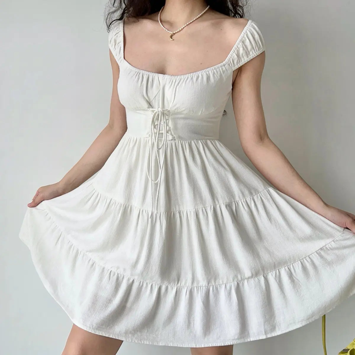 Model in white corset tiered mini dress, front view