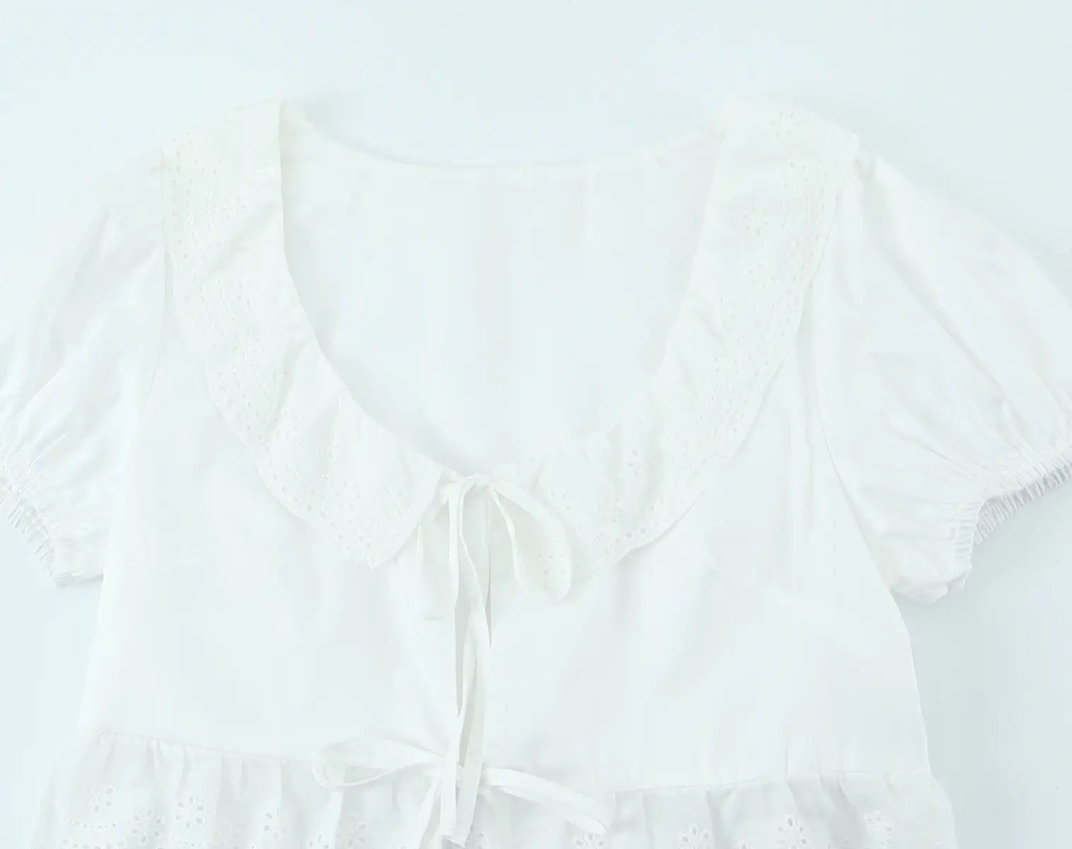 Keyhole front and tie closure detail of white lace crop top
