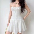 Model wearing white embroidered eyelet spaghetti-strap mini dress with floral appliqué, cottagecore summer dress