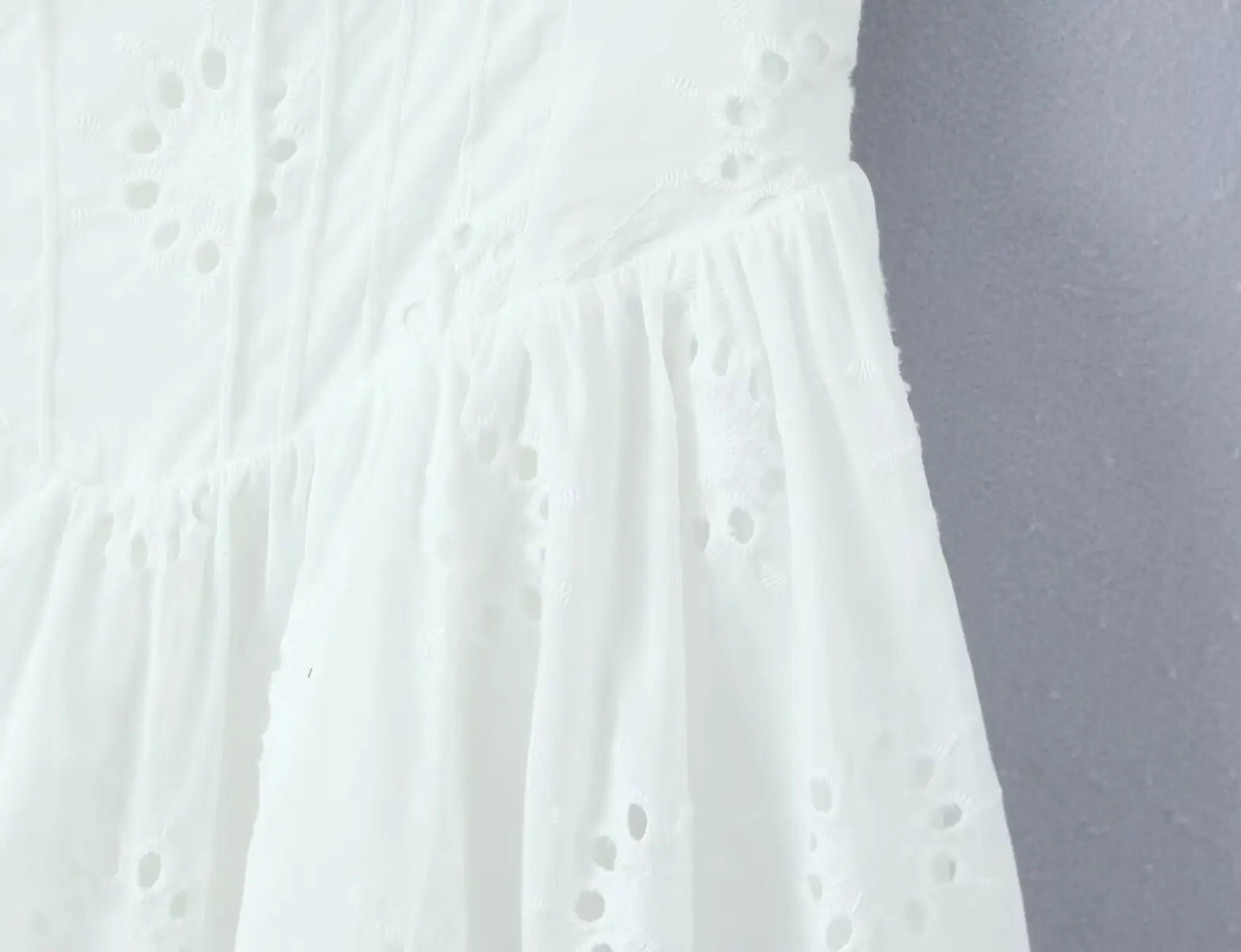 Close-up of eyelet embroidery texture on the corset-style bodice