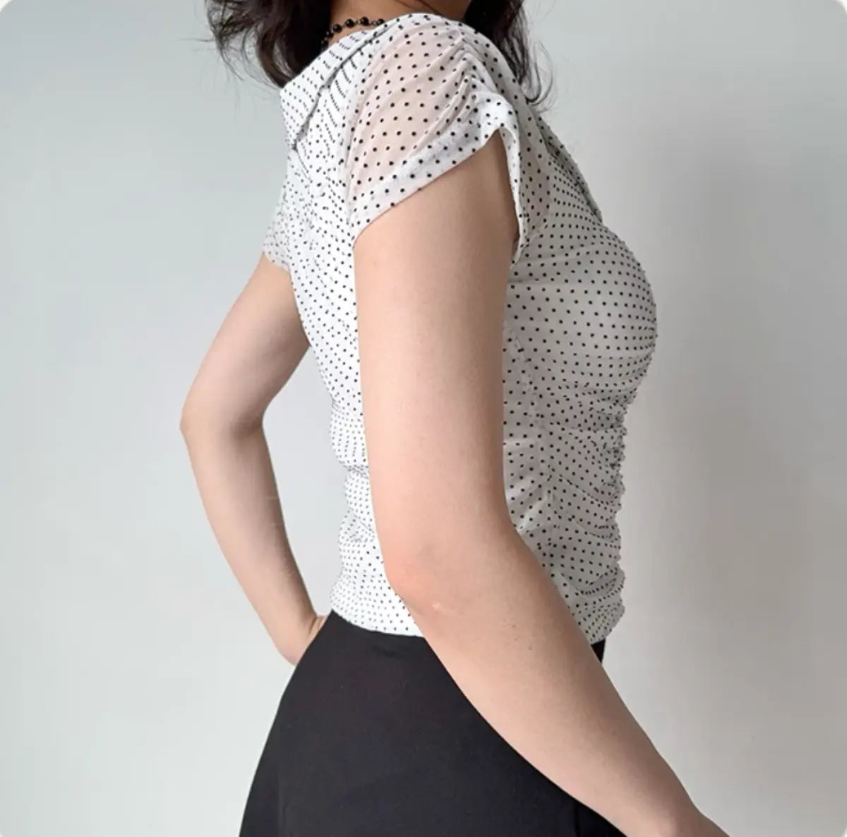 Back view of white eyelet lace top with puff sleeves and cropped, fitted hem