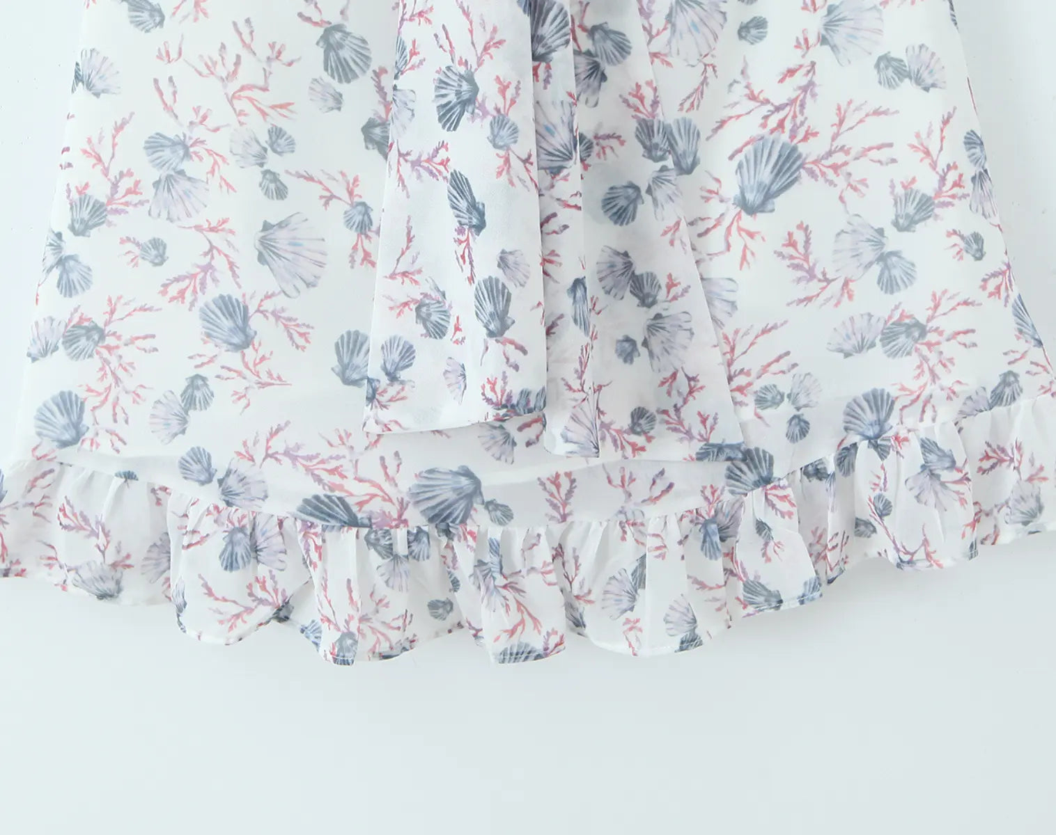 Ruffled hem detail of white floral cami mini dress