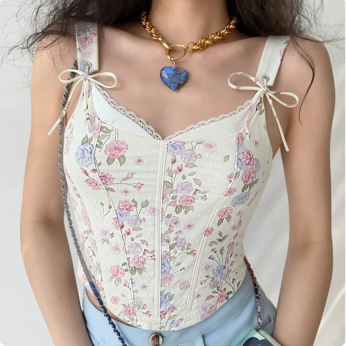 Model wearing white floral print cami corset top with lace trim and bow straps, romantic vintage-inspired top