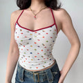 Model wearing white fruit-print halter-neck cami top with red trim, front ruched detail and fitted silhouette