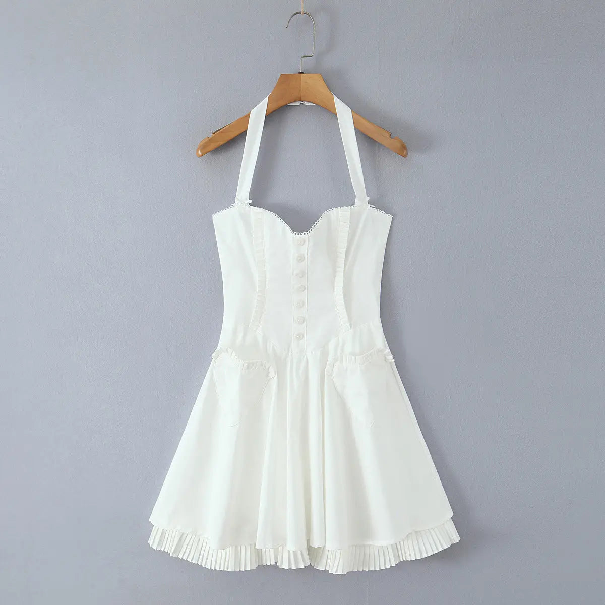 White halter corset dress hanging on wooden hanger, front view