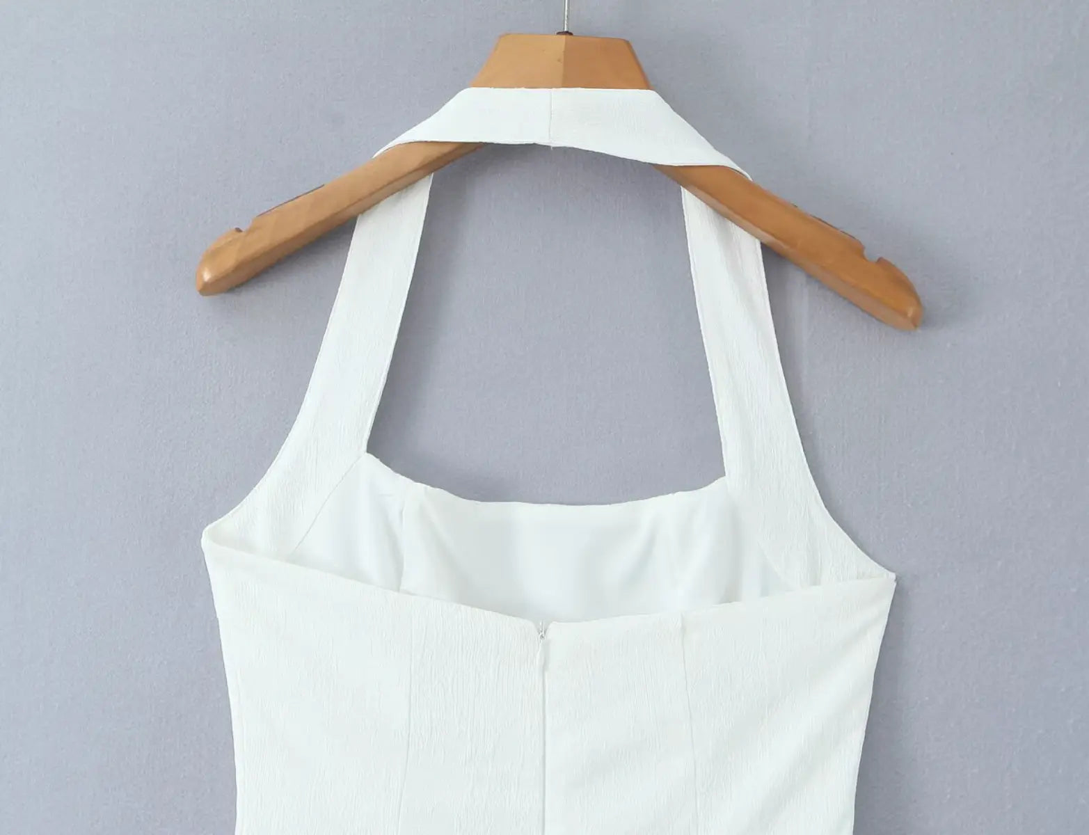Close-up of halter neckline and back bodice on white mini dress