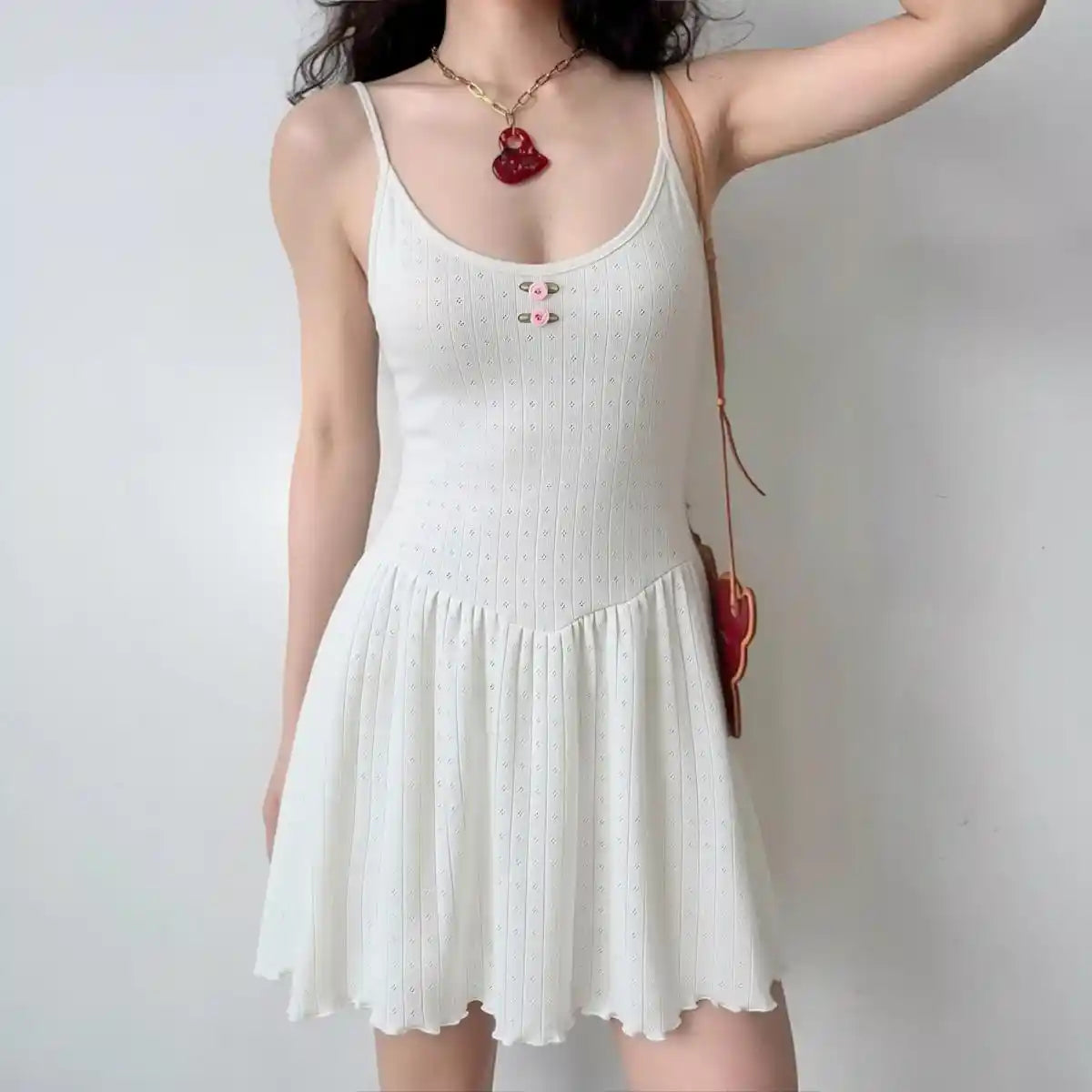 Model wearing white knit eyelet spaghetti-strap mini dress with ruffle hem, casual feminine summer dress