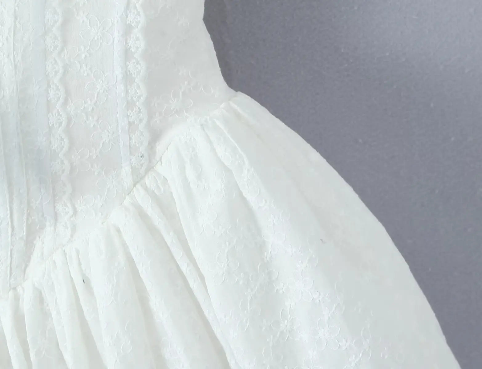 Close-up of embroidered lace texture on the corset-style bodice