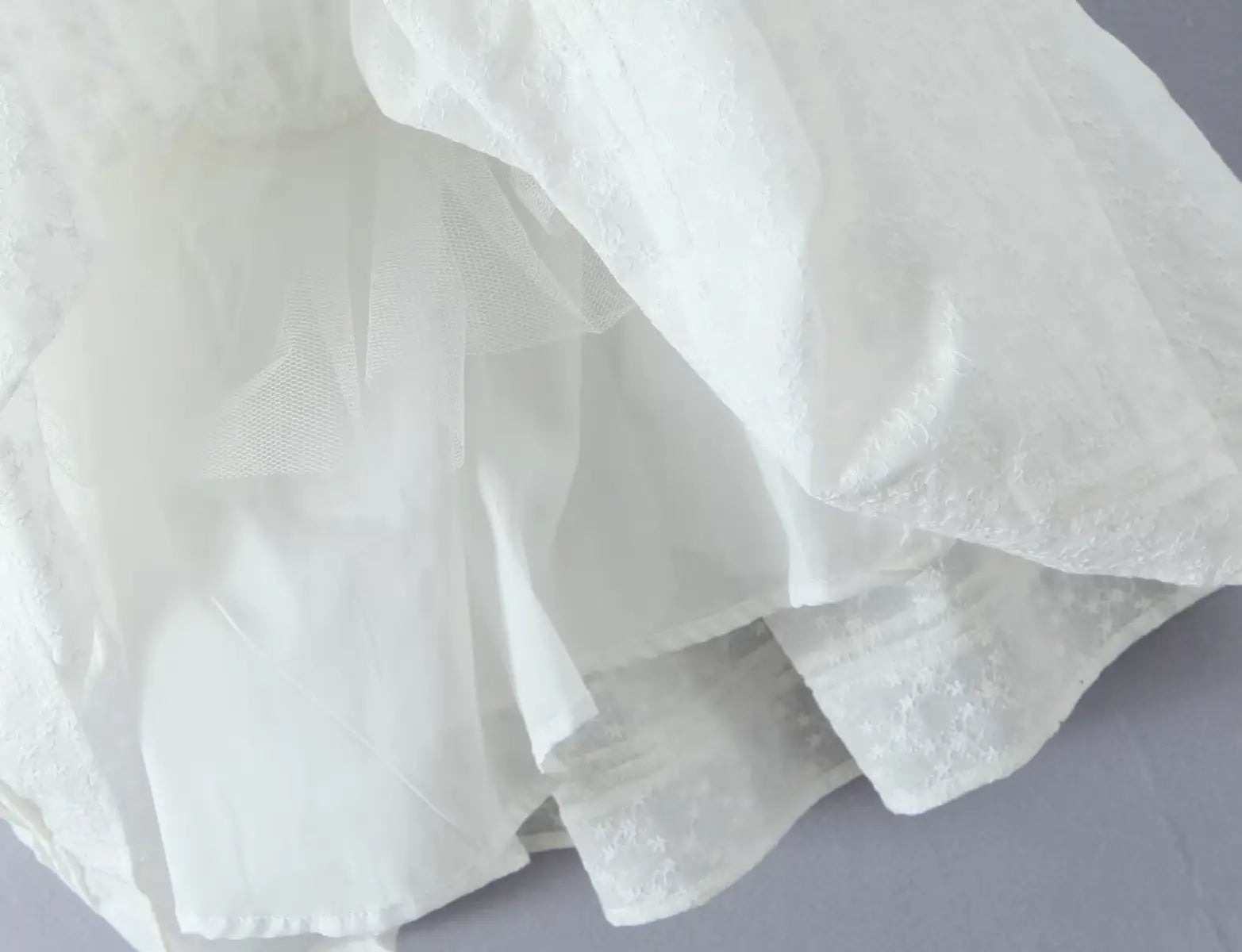 Close-up of layered fabric lining and texture on white lace cami dress