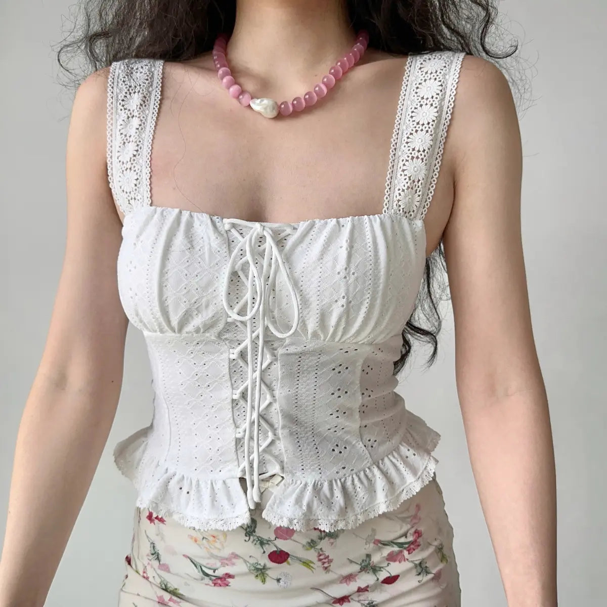 Model wearing white lace eyelet lace-up cami top, front view