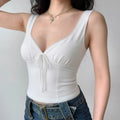 Model wearing white lace-trim bow-front sleeveless tank top, fitted feminine camisole