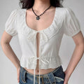 Model wearing white lace-trim keyhole crop top, front view