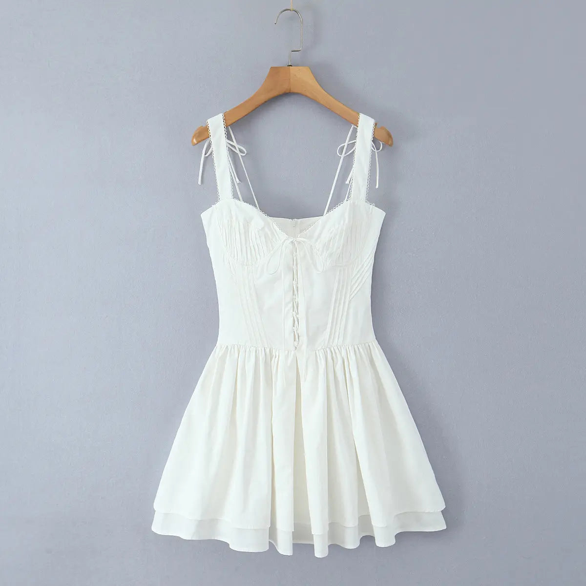 Front view of white lace-up corset cami dress on wooden hanger