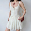 Model wearing white lace-up corset cami dress