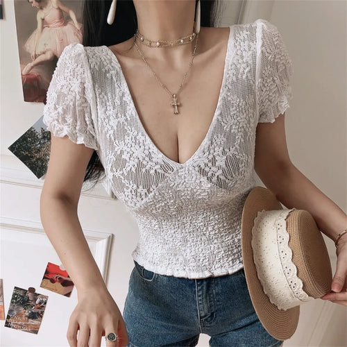 Model wearing white lace V-neck top with puff short sleeves, smocked fitted waist, and nude lining