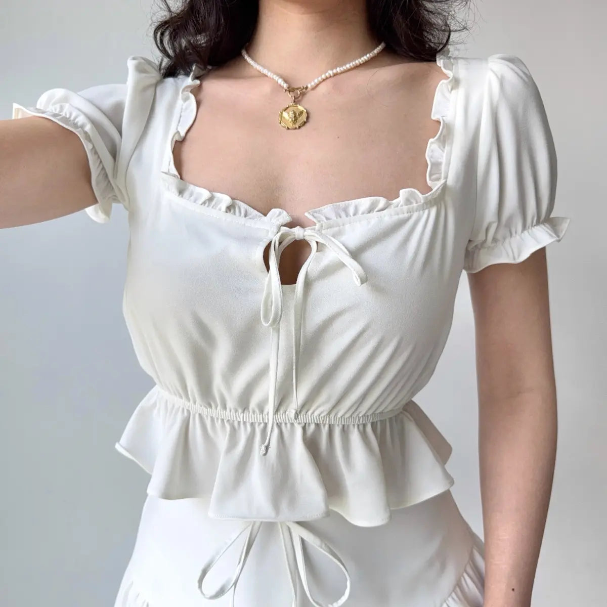White peplum top showing puff sleeve fit