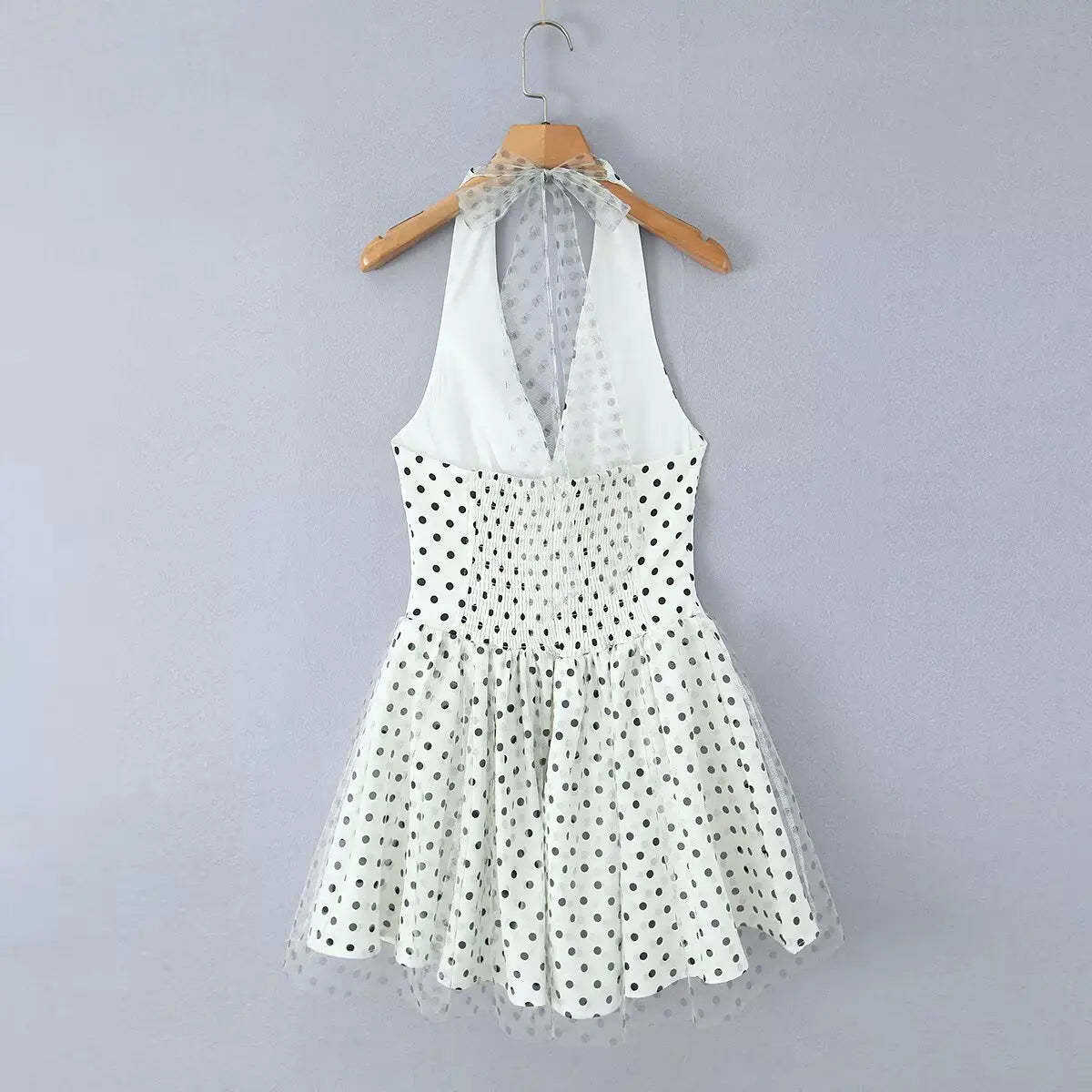 White polka dot halter mini dress, back view with keyhole neckline on white background