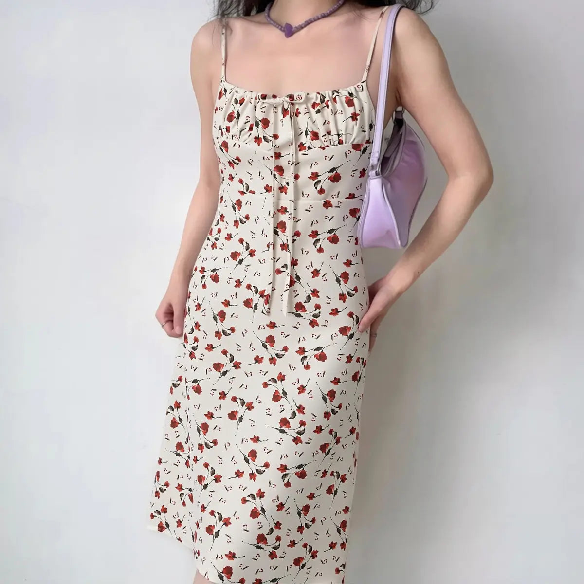 Model wearing white midi cami dress with red floral print, front view