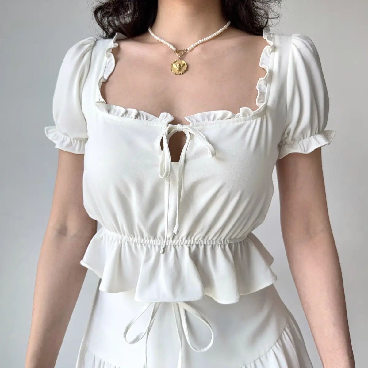 White ruffle peplum top with square neck and puff sleeves